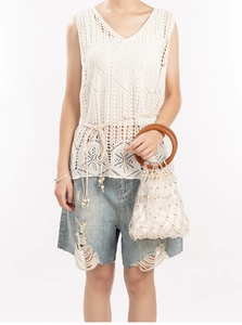 Close-up of contrast woven beaded handbag with round wooden handles and satin lining