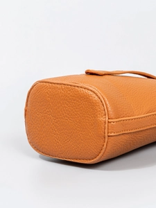 Detalle inferior del bolso bandolera de cuero granulado caramelo con costuras reforzadas