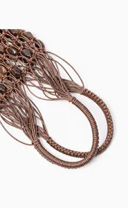 Gros plan détaillé du tissage en corde cirée marron foncé avec perles en pierre naturelle