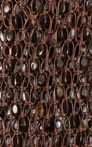 Détail d'un sac tissé à la main avec cordons marron foncé et perles en pierre naturelle