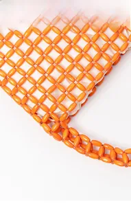 Detail of orange wooden bead bag with hand-woven grid pattern and white fabric lining