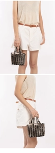 Detail of handmade hollow wooden bead tote with contrast color weaving and top handle