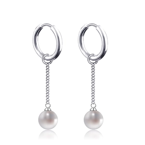 Detail of silver drop earrings with cross chains and white round pearls in close-up
