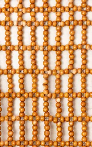 Macro detail of hand-woven natural wooden beads and mesh structure on the handbag