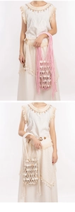 Detail of bohemian handmade woven mesh bag with natural shell pieces in white and pink