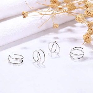 Minimalist silver ear cuff set with double-layer and cross geometric designs on fabric