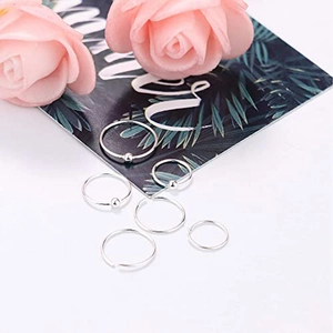 Detailopname van een zesdelige zilveren metalen piercingringenset met kralen en gladde rand