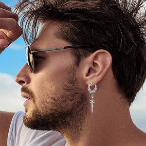 Close-up of a silver sword dangle earring for men worn by a model in outdoor setting