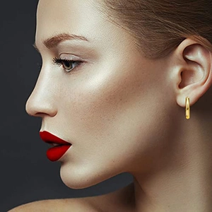 Set classico di 12 paia di orecchini a cerchio dorati indossati da modella