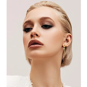 Golden cross pendant earrings with long chain and spike detail on female model