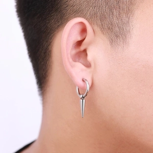 Close-up of a silver stainless steel spike drop earring worn on a person's ear lobe