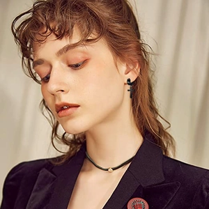 Mens black cross dangle earrings in matte finish stainless steel on a model