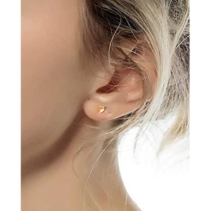 Puce d'oreille coeur doré avec zircon orange, vue rapprochée sur l'oreille du mannequin