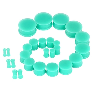 Macro view of mint green silicone ear gauges set arranged in a spiral on white background