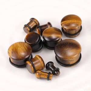 Detailed macro view of tiger eye stone ear plugs with black O-rings in various sizes