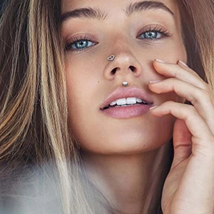 Set di piercing al naso a cuore d'argento e labret a sfera indossati da una modella