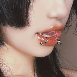 Punk stainless steel horseshoe lip rings and devil spikes shown on model's lower lip