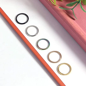 Detail view of twisted stainless steel piercing rings in five metallic finishes
