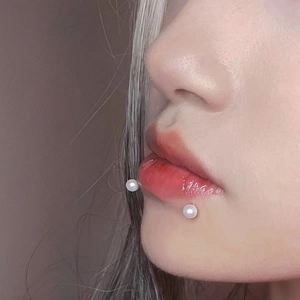 Minimalist stainless steel 16G lip rings featuring white pearls on the lower lip