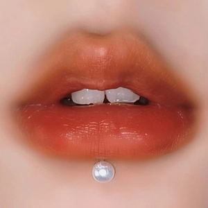 Macro view of a round white pearl labret stud on lips with high gloss finish