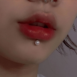 Detail shot of a minimalist stainless steel labret stud with a white round pearl