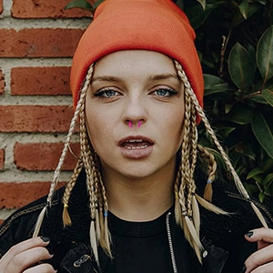 Pink acrylic septum piercing ring in curved bull horn shape shown on a female model