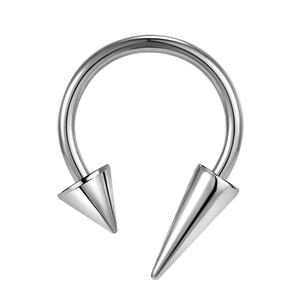 Macro detail of silver stainless steel horseshoe ring with asymmetrical cone spikes