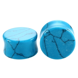Macro shot of double flared turquoise ear plugs with black marble texture for piercings