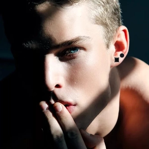 Ensemble de boucles d'oreilles noires rondes et carrées pour hommes portées par un mannequin