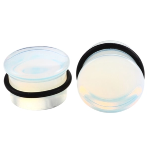 Macro detail of opal stone ear plugs with black rubber O-rings and iridescent finish
