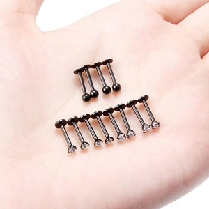 Set van 12 zwarte roestvrijstalen 16G labret piercings met kristallen en bollen op hand