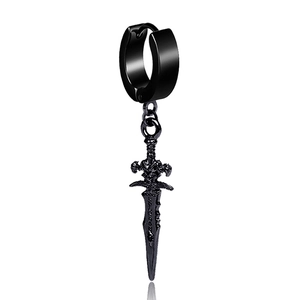 Gros plan sur la boucle d'oreille poignard noire punk avec gravure et reflet sur fond blanc