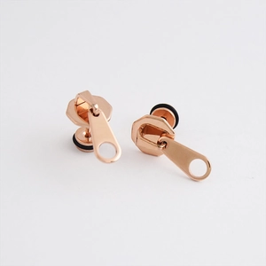 Vista de primer plano de pendientes con forma de cremallera en acero inoxidable oro rosa