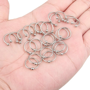 Primer plano de piercings circulares de acero inoxidable en la mano para ver el tamaño
