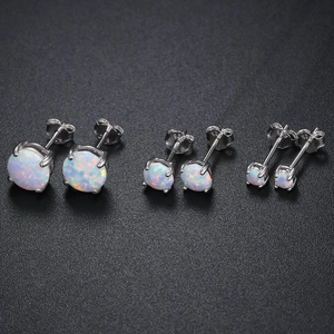 Macro detail of three sizes of white opal stud earrings with S925 sterling silver four-prong setting