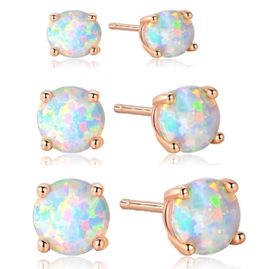 Three pairs of white opal stud earrings in rose gold four-prong setting of various sizes