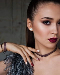 Close-up of model wearing 4-prong white opal stud earrings and a beaded choker necklace
