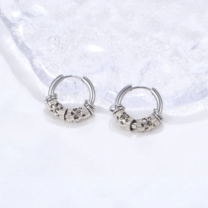 Silver stainless steel hoop earrings with Celtic knot engraved spherical charms on silk