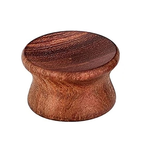 Dettaglio macro di un plug per orecchio in legno a doppia svasatura con texture lucida