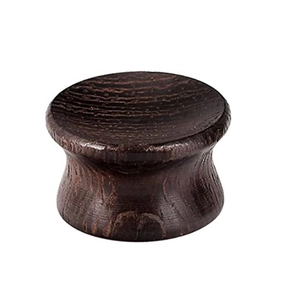 Dettaglio macro del plug auricolare concavo in legno marrone scuro con venature naturali