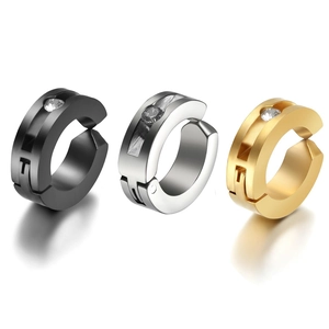 Detailed view of three polished metal ear cuffs in black, silver, and gold with rhinestones