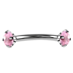 Detailed view of silver curved barbell with four-claw set pink zircons for eyebrow piercing