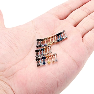 Détail macro de piercings en acier inoxydable multicolores avec strass sur la paume d'une main