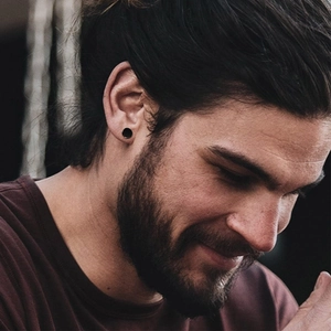 Boucles d'oreilles noires minimalistes pour hommes portées à l'oreille en extérieur