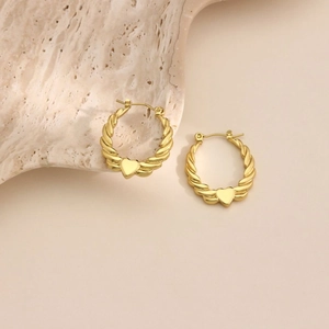 Irregular hammered gold earrings with heart charm and twisted spiral texture on stone