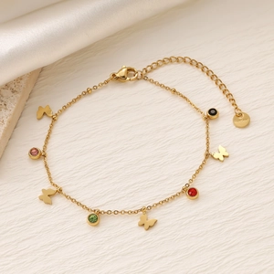 Dettaglio di bracciale in titanio dorato con ciondoli in zircone e logo S.Steel