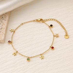 Dettaglio di un bracciale in acciaio inossidabile dorato con stelle e zirconi colorati