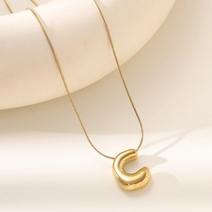 Polished 18K gold letter C bubble pendant on a fine snake chain necklace