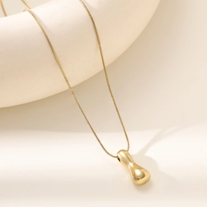 Macro view of 18K gold plated polished teardrop pendant with sleek snake chain necklace