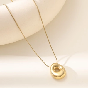 Detail of 18K gold balloon bubble letter pendant on a glossy polished snake chain
